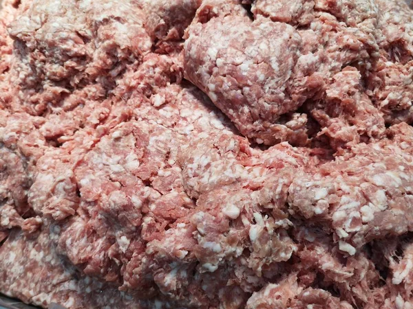 Ground pork on a stainless steel tray in supermarket