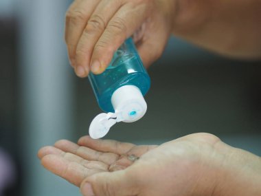 Kadın parmaklarıyla yüzde 70 alkollü jeli parmak uçlarında jelatin ile ovmak için bekliyor. Korona virüsünü korumak için, covid19, el dezenfektanı