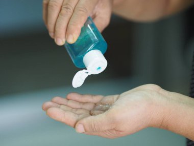 Kadın parmaklarıyla yüzde 70 alkollü jeli parmak uçlarında jelatin ile ovmak için bekliyor. Korona virüsünü korumak için, covid19, el dezenfektanı