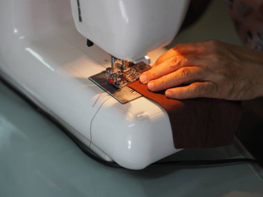 Evde oturan kadın, toz ve mikroplar için maske dikiyor. Öğleden sonra 2.5, virüs örtüsü 19.