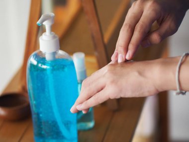 Çocuk parmaklarıyla elinde jel alkolü ellerinin arkasına yüzde 70 jelatin ile sürterek Corona virüsünü, covid19 'u, el dezenfektanını korumak için duruyor.