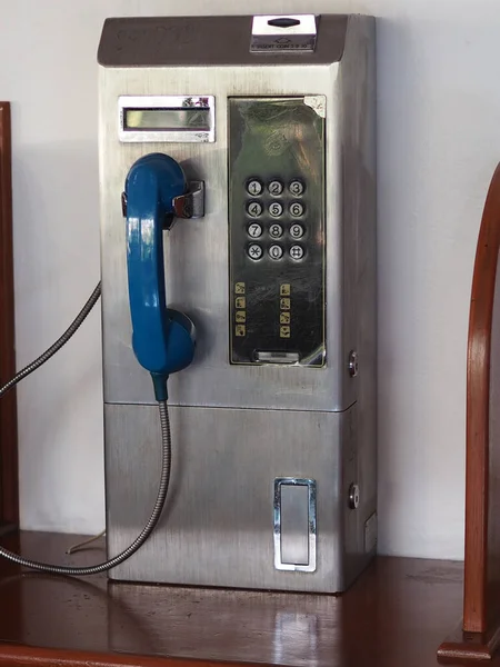 公衆電話は木製の棚にあるステンレス製です — ストック写真