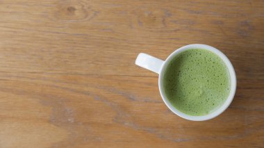 Portre bir fincan yeşil çay gün ışığına temiz ahşap tablo. metin tasarım için alan. Aroma aşk kafein koku.