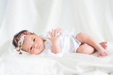 Sevimli bebek bebek beyaz arka plan kavramı Uluslararası günü kız çocuğunun gözbebeği ile yatakta uyuyan iki hafta Hıristiyan vaftiz yeni doğan bebek