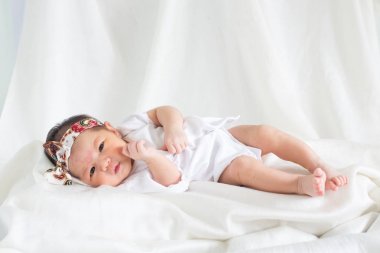 Sevimli bebek bebek beyaz arka plan kavramı Uluslararası günü kız çocuğunun gözbebeği ile yatakta uyuyan iki hafta Hıristiyan vaftiz yeni doğan bebek