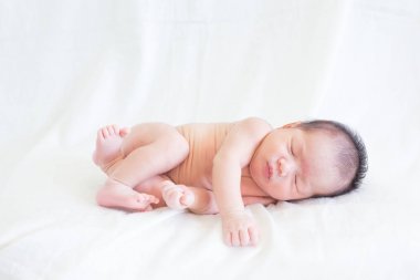 Sevimli bebek bebek beyaz arka plan kavramı Uluslararası günü kız çocuğunun gözbebeği ile yatakta uyuyan iki hafta Hıristiyan vaftiz yeni doğan bebek