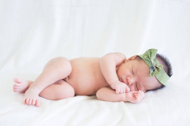 Sevimli bebek bebek beyaz arka plan kavramı Uluslararası günü kız çocuğunun gözbebeği ile yatakta uyuyan iki hafta Hıristiyan vaftiz yeni doğan bebek