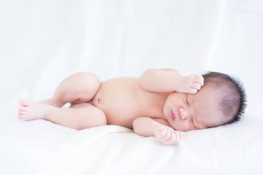 Sevimli bebek bebek beyaz arka plan kavramı Uluslararası günü kız çocuğunun gözbebeği ile yatakta uyuyan iki hafta Hıristiyan vaftiz yeni doğan bebek