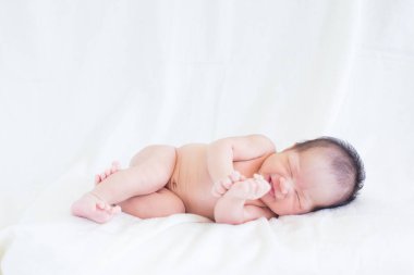 Sevimli bebek bebek beyaz arka plan kavramı Uluslararası günü kız çocuğunun gözbebeği ile yatakta uyuyan iki hafta Hıristiyan vaftiz yeni doğan bebek