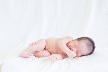 Sevimli bebek bebek beyaz arka plan kavramı Uluslararası günü kız çocuğunun gözbebeği ile yatakta uyuyan iki hafta Hıristiyan vaftiz yeni doğan bebek