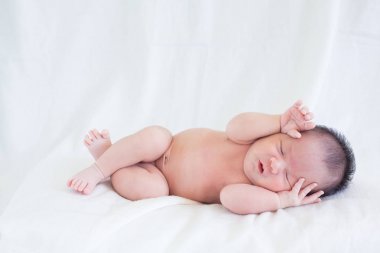 Sevimli bebek bebek beyaz arka plan kavramı Uluslararası günü kız çocuğunun gözbebeği ile yatakta uyuyan iki hafta Hıristiyan vaftiz yeni doğan bebek