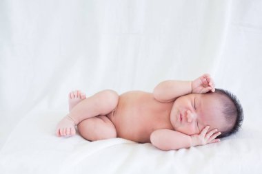 Sevimli bebek bebek beyaz arka plan kavramı Uluslararası günü kız çocuğunun gözbebeği ile yatakta uyuyan iki hafta Hıristiyan vaftiz yeni doğan bebek