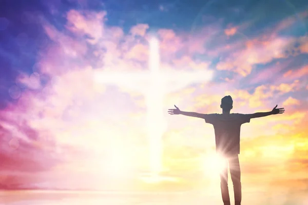 Silhouette of man with raised hands over blur cross concept for — Stock Photo, Image