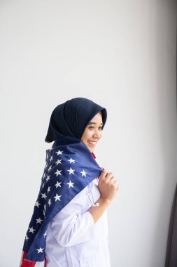 Genç Müslüman kadınlar, Amerikan bayrağını beyaz arka plan kavramının üzerinde tutan öğrenci burslarını değiştiriyor.