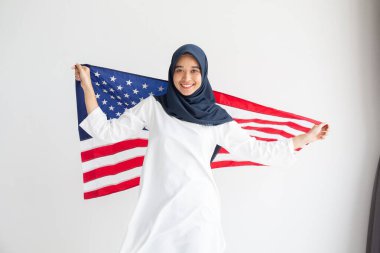 Genç Müslüman kadınlar, Amerikan bayrağını beyaz arka plan kavramının üzerinde tutan öğrenci burslarını değiştiriyor.