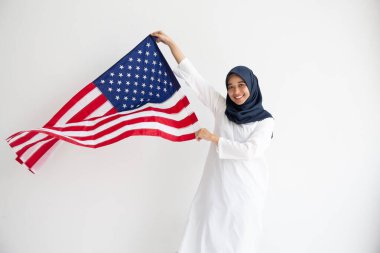 Genç Müslüman kadınlar, Amerikan bayrağını beyaz arka plan kavramının üzerinde tutan öğrenci burslarını değiştiriyor.