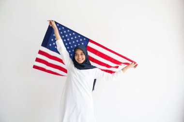 Genç Müslüman kadınlar, Amerikan bayrağını beyaz arka plan kavramının üzerinde tutan öğrenci burslarını değiştiriyor.