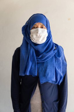 Tıbbi maskeli Asyalı kadın Coronavirus pandemik hastalığı geçmişi izole eder. Malezya salgınından küresel salgına kadar COVID-19 virüsü, insan sosyal mesafesi için Endonezya konsepti, Solunum Hastalığı