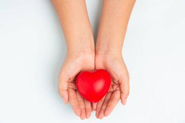 Kadın doktor elleri, hastanenin kan bakımı konsepti panoramik dünya kalp ve sağlık günü, CSR toplumu, çocuk organlarını desteklemek için geniş mavi arka planda kırmızı kalp bağışı yapıyor.
