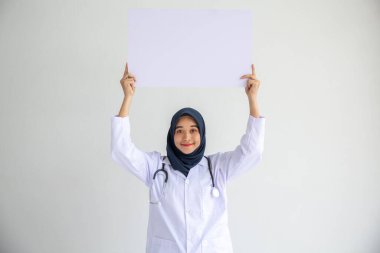 Genç Arap doktor kadın gülümsemesi, İslam için izole edilmiş beyaz arkaplan kavramında tıbbi hastane sağlık hizmetlerinde çalışan insanlar, modern hemşire pandemik iş hizmetlerinde tesettür takıyor.