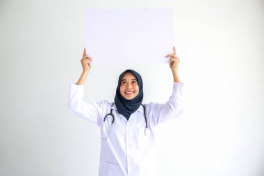 Genç Arap doktor kadın gülümsemesi, İslam için izole edilmiş beyaz arkaplan kavramında tıbbi hastane sağlık hizmetlerinde çalışan insanlar, modern hemşire pandemik iş hizmetlerinde tesettür takıyor.