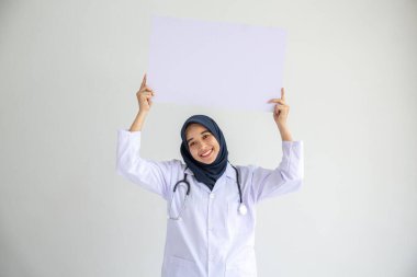 Genç Arap doktor kadın gülümsemesi, İslam için izole edilmiş beyaz arkaplan kavramında tıbbi hastane sağlık hizmetlerinde çalışan insanlar, modern hemşire pandemik iş hizmetlerinde tesettür takıyor.