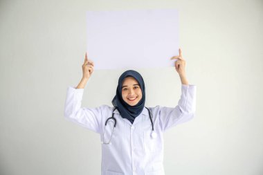 Genç Arap doktor kadın gülümsemesi, İslam için izole edilmiş beyaz arkaplan kavramında tıbbi hastane sağlık hizmetlerinde çalışan insanlar, modern hemşire pandemik iş hizmetlerinde tesettür takıyor.