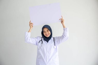Genç Arap doktor kadın gülümsemesi, İslam için izole edilmiş beyaz arkaplan kavramında tıbbi hastane sağlık hizmetlerinde çalışan insanlar, modern hemşire pandemik iş hizmetlerinde tesettür takıyor.