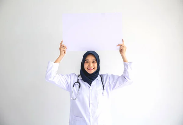 年轻的阿拉伯穆斯林医生女性微笑着在隔离卡片上显示出白人背景的观念 为从事医院医疗保健工作的伊斯兰人士服务 现代护士在大流行的商业服务中佩戴头巾 — 图库照片