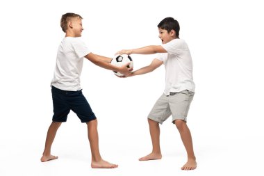 naughty boy taking soccer ball away from brother on white background