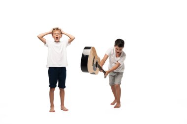 two brothers looking at camera and dancing while listening music in headphones on white background clipart