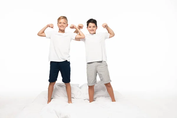 Zwei Brüder Imitieren Bodybuilder Während Sie Isoliert Auf Weißem Bett — Stockfoto