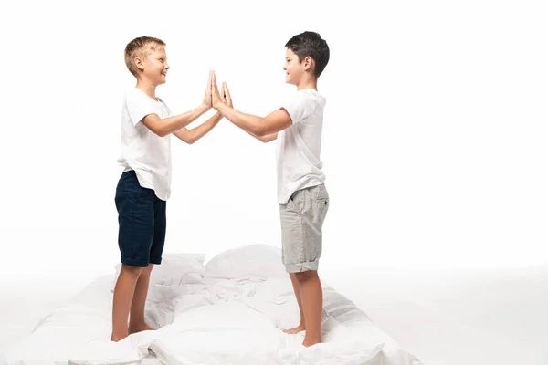 Dois Irmãos Sorridentes Batendo Palmas Enquanto Estavam Cama Isolados Branco — Fotografia de Stock