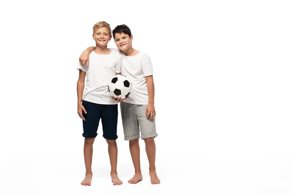 two brothers looking at camera and dancing while listening music in headphones on white background