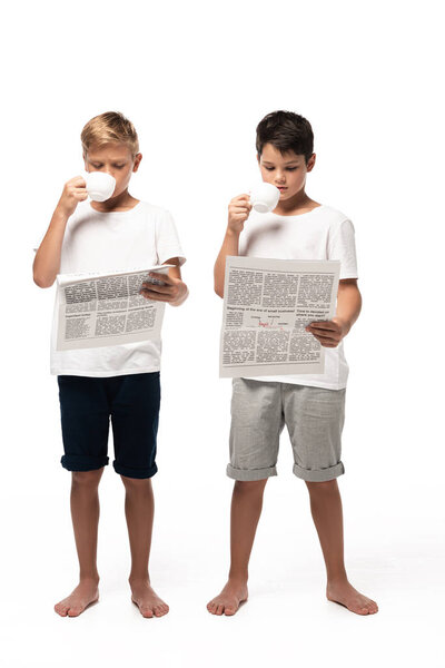 два брата смотрят на камеру и танцуют, слушая музыку в наушниках на белом фоне
