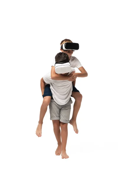 男孩骑背兄弟 在白色背景下一起使用Vr耳机 — 图库照片
