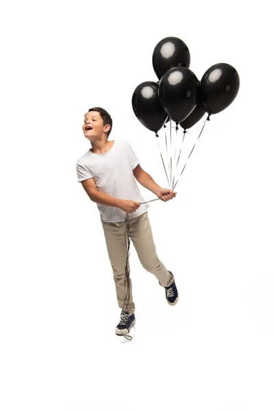 Excited Boy Looking Away While Holding Black Balloons White Background — Stock Photo, Image