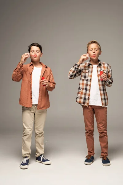 Vista Frontal Dos Hermanos Soplando Burbujas Jabón Sobre Fondo Gris — Foto de Stock