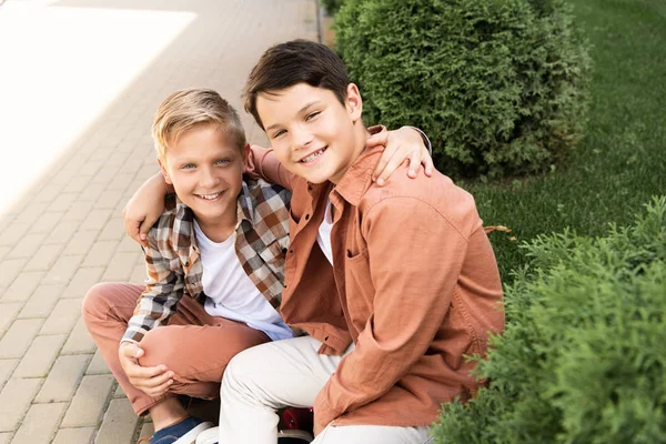 Dos Hermanos Alegres Sonriendo Sentados Pavimento Mirando Cámara — Foto de Stock
