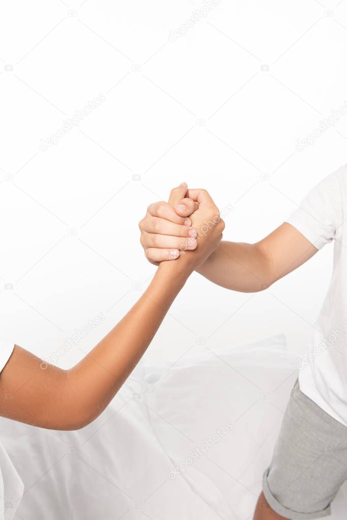 cropped view of boys holding hands isolated on white 