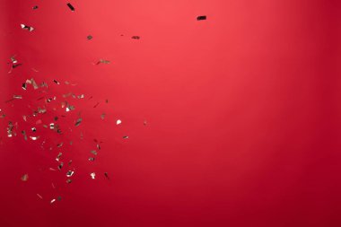 view of golden confetti isolated on red with copy space clipart