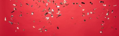 panoramic shot of christmas golden confetti isolated on red clipart