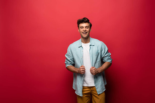 handsome man cheerful posing in casual clothes isolated on red