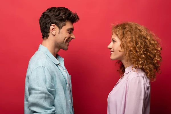 Beautiful Happy Couple Casual Clothes Looking Each Other Isolated Red — Φωτογραφία Αρχείου