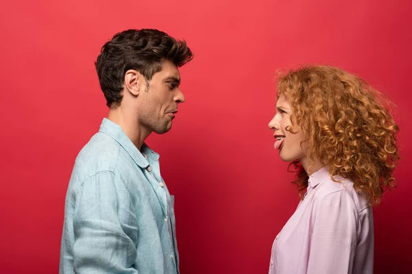 Beautiful Couple Looking Each Other Making Grimaces Isolated Red — Stock Photo, Image