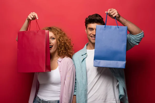 Beautiful Smiling Couple Holding Shopping Bags Isolated Red — Stock Photo, Image