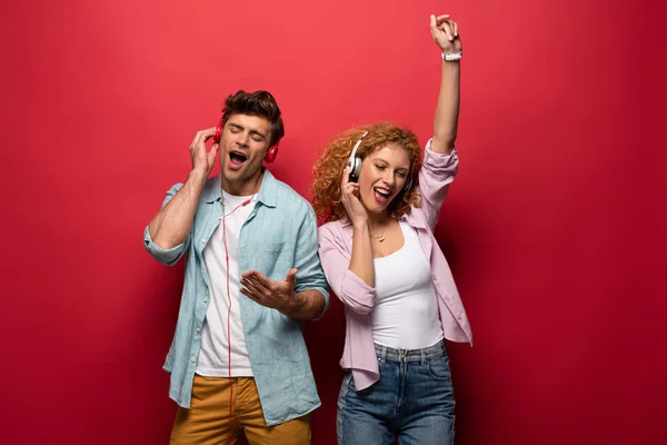 Happy Couple Dancing Singing Listening Music Headphones Together Isolated Red — Stock Photo, Image