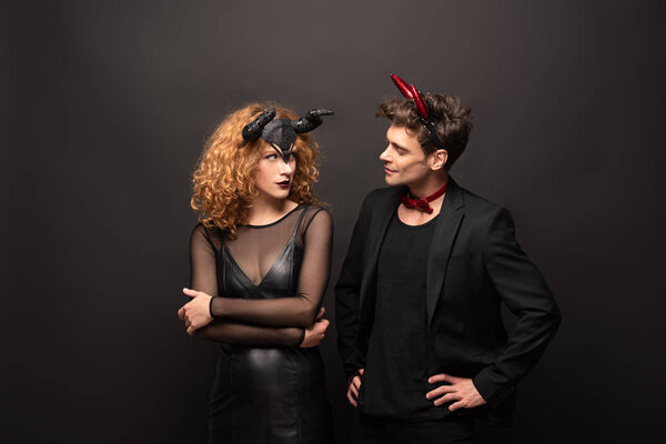 beautiful couple posing in halloween costumes on black