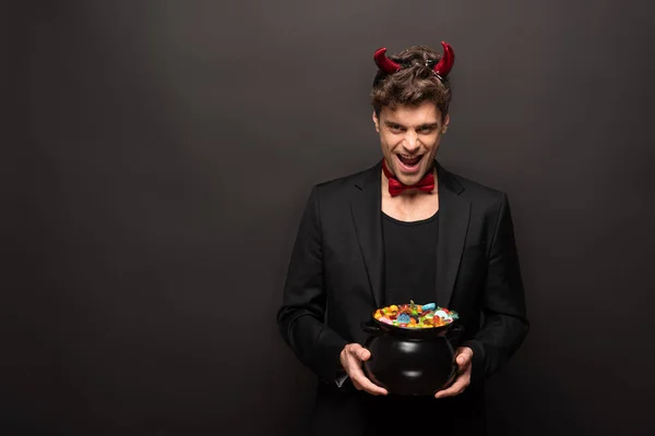 Handsome Laughing Man Devil Costume Holding Pot Candies Black — Stock Photo, Image