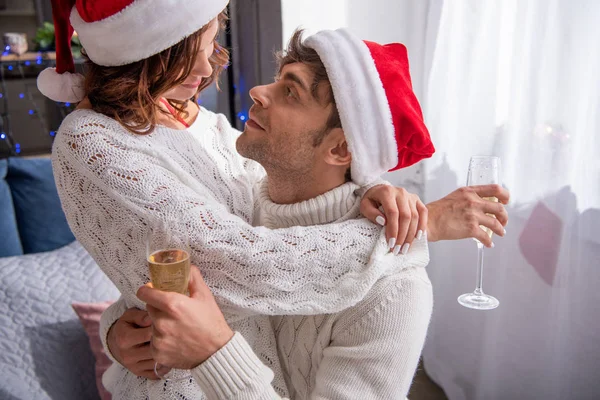 Boyfriend Girlfriend Santa Hats Hugging Holding Champagne Glasses Christmastime — Stock Photo, Image